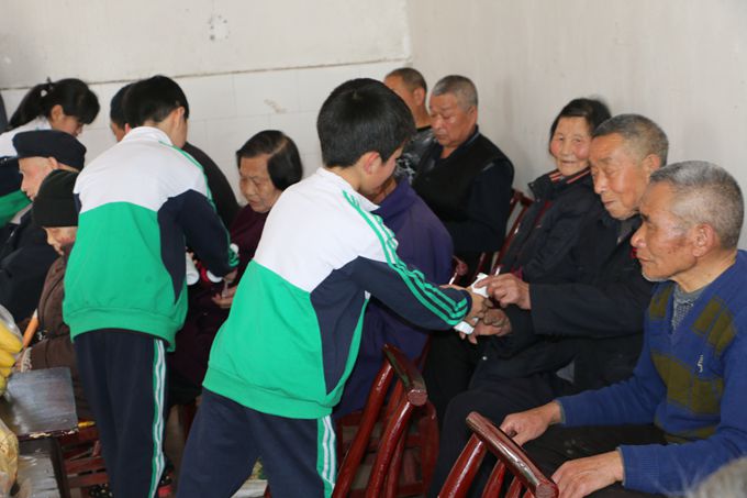 志愿者向老人敬献水果、饮料等.JPG